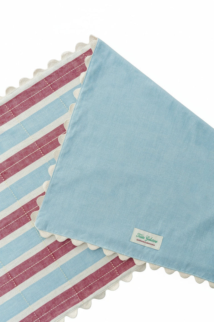 Two fabric swatches, one striped and one solid with scalloped edges